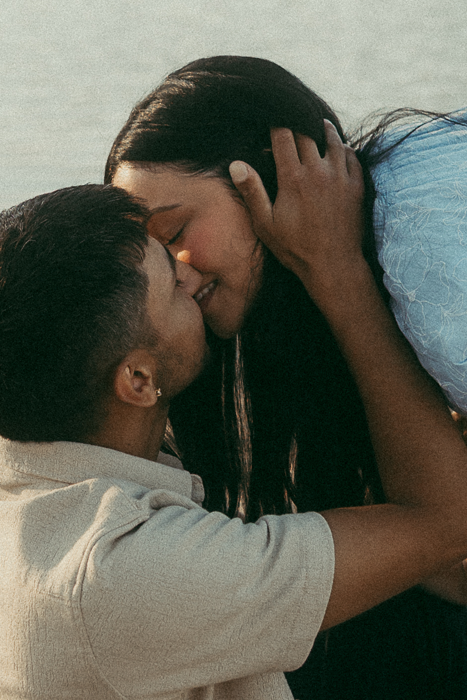 Close-up of a couple kissing during a golden hour lakeside engagement session in Omaha, Nebraska
